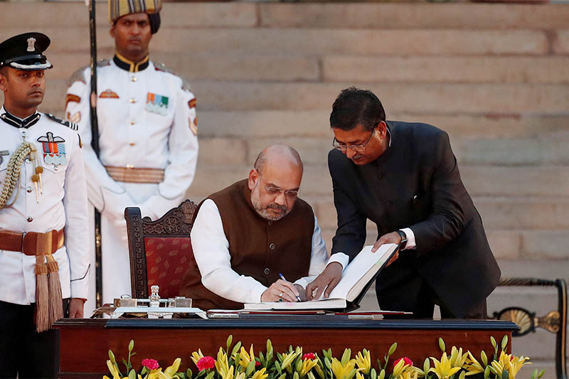 Amit Shah signs documents after taking his oath as a cabinet minister during a swearing-in ceremony at the presidential palace in New Delhi, India May 30, 2019. Photo: Reuters