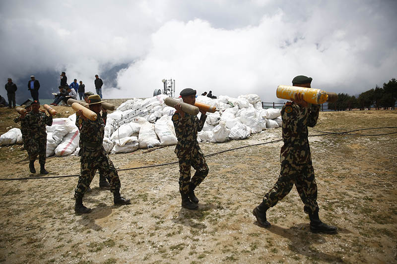 Nepal Army personnel carry oxygen cylinders collected from the high camps of Mount Everest during the Everest Clean-up Campaign at Namche Bazaar, on Monday, May 27, 2019. Photo: Skanda Gautam/THT