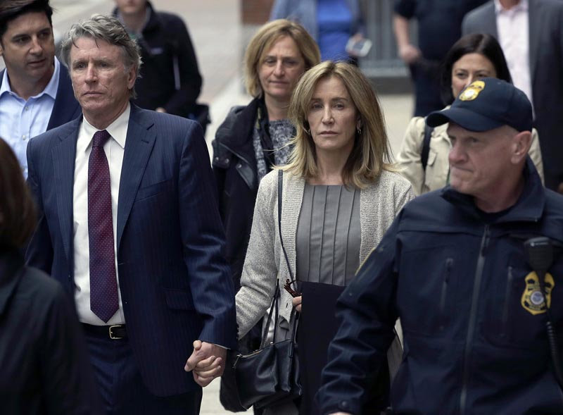 Felicity Huffman, center, departs federal court with her brother Moore Huffman Jr., left, Monday, May 13, 2019, in Boston, where she pleaded guilty to charges in a nationwide college admissions bribery scandal. Photo: AP