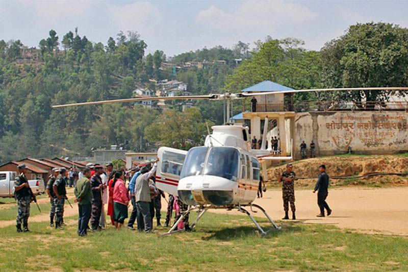 Officials helping new mother to board a chopper in Bhojpur district, on Monday, May 06, 2019. Photo: Niroj Koirala/THT