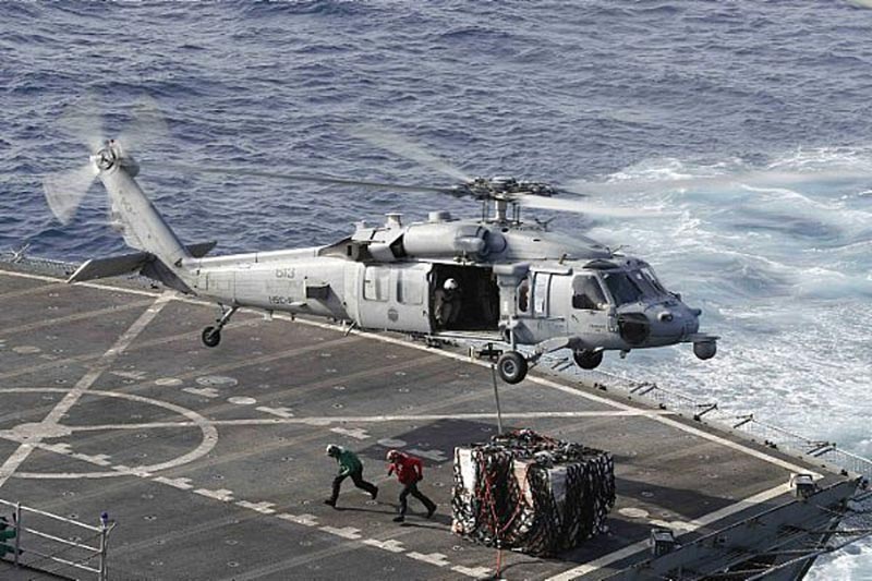 In this Sunday, May 19, 2019 photo, an MH-60S Sea Hawk helicopter transports cargo from the fast combat support ship USNS Arctic to the Nimitz-class aircraft carrier USS Abraham Lincoln during a replenishment-at-sea operation in the Arabian Sea, as Mideast tensions remain high between Tehran and the United States. Photo: Associated Press