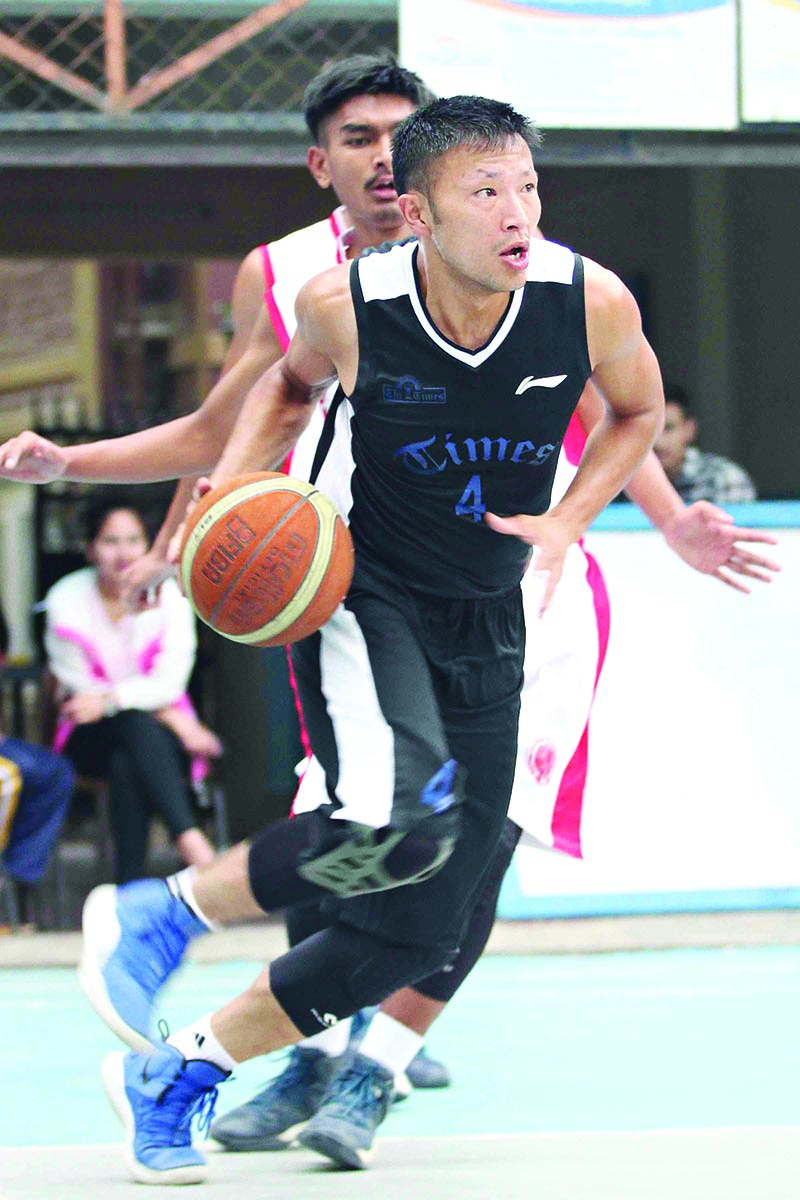 Sadhish Pradhan of Times International Club drives the ball past an ANK Kirtipur Basketball Team player during their Kwiks Nepal Basketball League match in Kathmandu on Wednesday. Photo: Udipt Singh Chhetry / THT