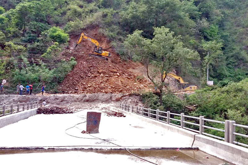 Two excavators are seen digging a roadside hill across a bridge over Trishuli River along the Prithvi Highway in Aanbukhaireni Rural Municipality of Tanahun district, on Thursday, May 30, 2019. Photo: Madan Wagle/THT
