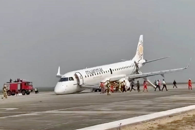 An evacuated passenger records on her phone as firefighters attend to the scene after Myanmar National Airlines flight UB103 landed without a front wheel at Mandalay International Airport in Tada-U, Myanmar May 12, 2019 in this still image taken from social media video. Photo: Reuters