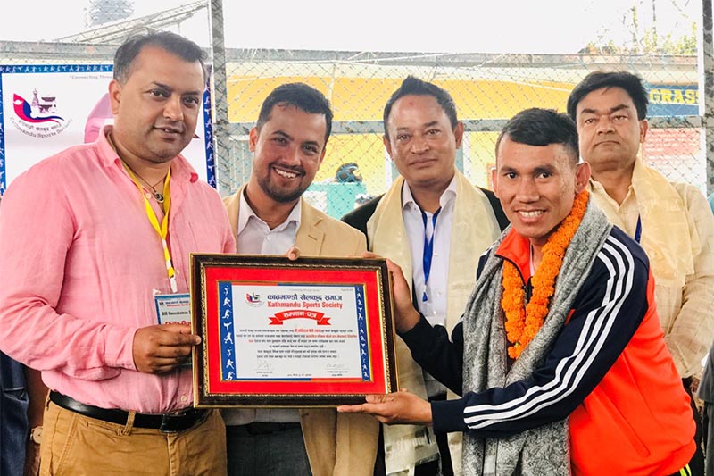 Former minister Gagan Thapa and President of the Society Badri Bhattarai hands over the felicitation letter to national para-taekwondo coach Kabiraj Negi Lama, in Kathmandu, on Friday, May 3, 2019. Photo: THT