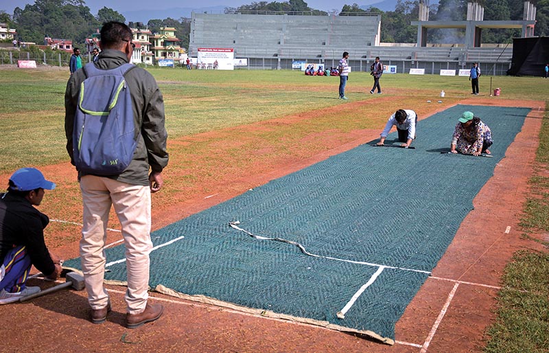 National cricket team head coach Jagat Tamatta watches ground staff laying down matting wicket at the Mulpani grounds for the Expert Prime Minister Cup One Day Cricket Tournament in Kathmandu on Sunday. Photo: Naresh Shrestha / THT