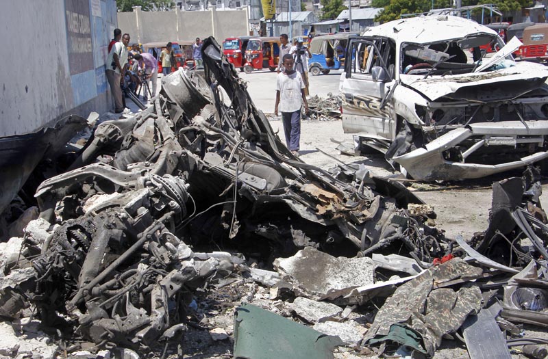 Somalis walk near the wreckage after a suicide car bomb attack in the capital Mogadishu, Somalia Wednesday, May 22, 2019. Photo: AP