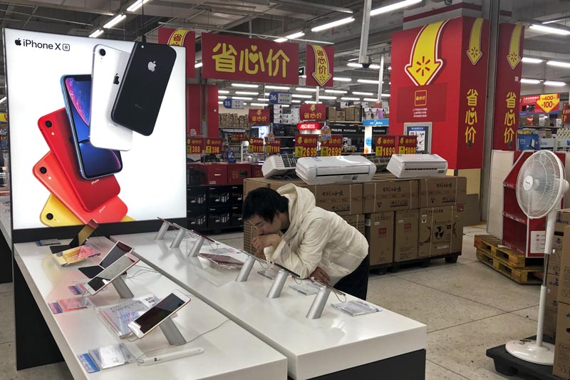 A man browses an iPhone unit on display at a section selling Apple's products together with Chinese made electric appliances at a hypermarket in Beijing, Thursday, May 9, 2019. Photo: AP