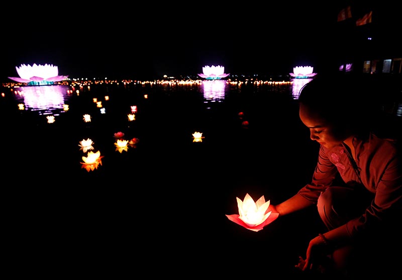 A Buddhist releases a candle into a lake as she prays during the Vesak Day, an annual celebration of the birth of Buddha, his attaining of Enlightenment and his passing away into Nirvana, at Tam Chuc Pagoda in Ba Sao town, Vietnam May 13, 2019.