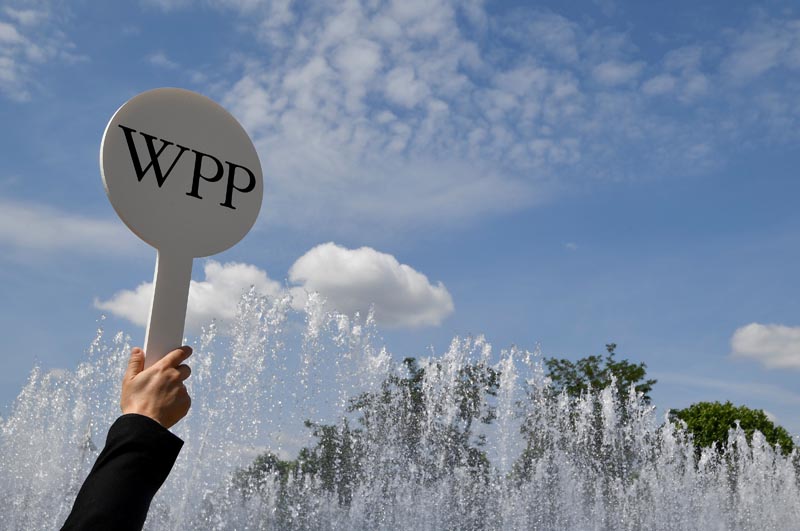 FILE PHOTO: An usher holds a baton to guide attendees towards the AGM of advertising agency WPP in London, Britain, June 13, 2018. Photo: Reuters