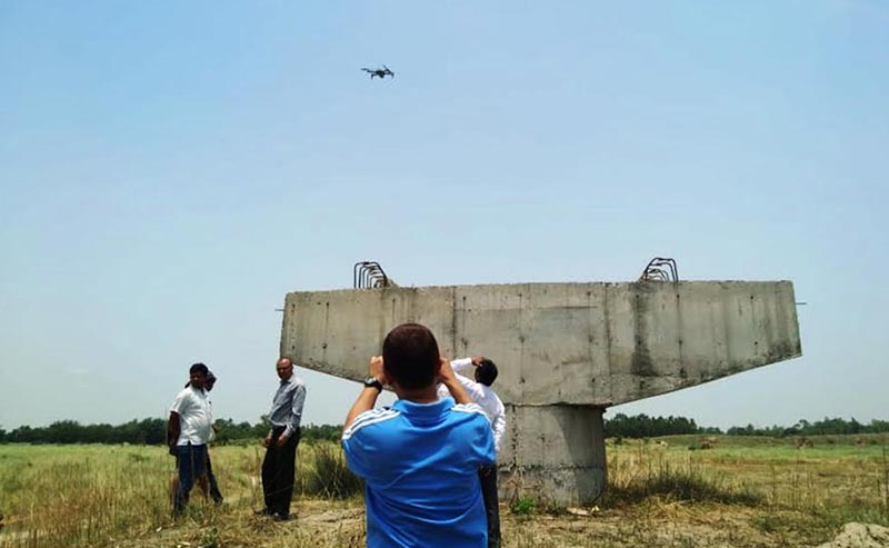 A technician reviewing the design of Bagmati Bridge with the aid of a drone in Durgabhagawati Rural Municipality, Rautahat, on Wednesday. Photo THT