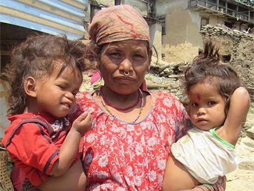 A woman with her undernourished children standing in front of her house in Aamkot of Budhiganga Municipality, Bajura, on Wednesday, June 19, 2019. Photo: THT