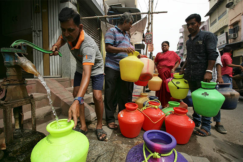 A man uses a hand-pump to fill up a container with drinking water as others wait in a queue on a street in Chennai, India, June 17, 2019. Photo: Reuters