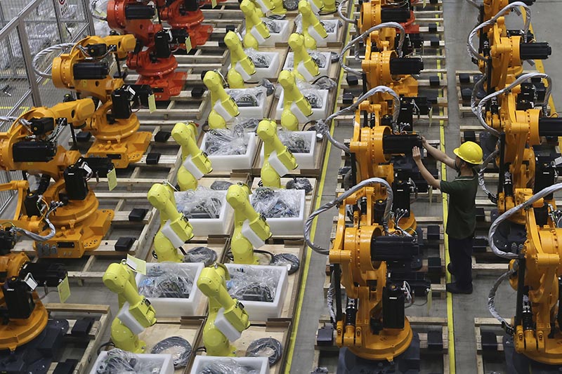 A worker checks on robot arms at a factory in Nanjing in east China's Jiangsu province, Thursday, June 6, 2019. Photo: Chinatopix via AP