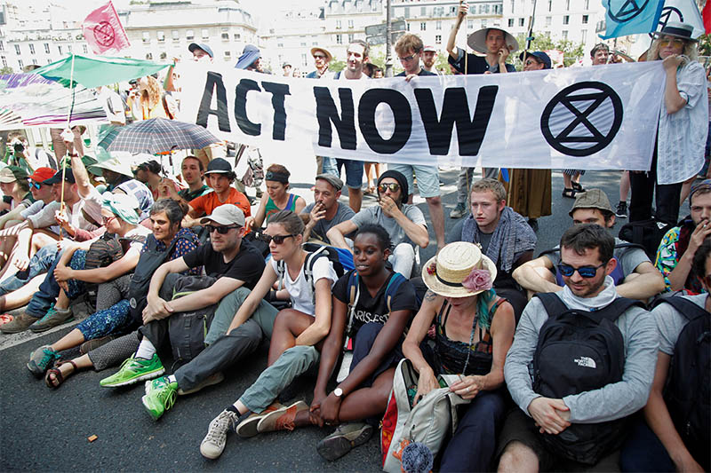 French youth and environmental activists block a bridge during a demonstration to urge world leaders to act against climate change, in Paris, France, June 28, 2019.  Photo: Reuters