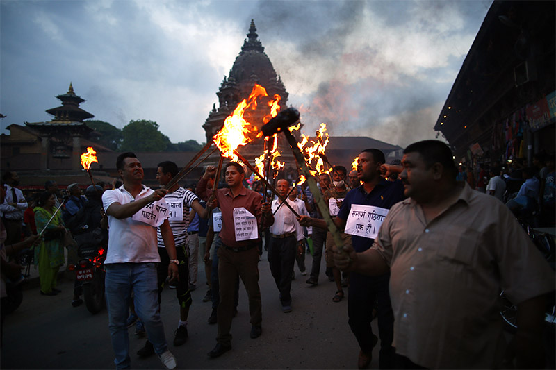 Members of indigenous Newar community take part in a torch protest against the controversial Guthi bill at Patan Durbar Square in Lalitpur, on Friday, June 14, 2019. The protesters demand that the government withdraw the Guthi bill registered at the National Assembly which envisions nationalizing all religious sites and trusts under a powerful commission. Photo: Skanda Gautam/THT