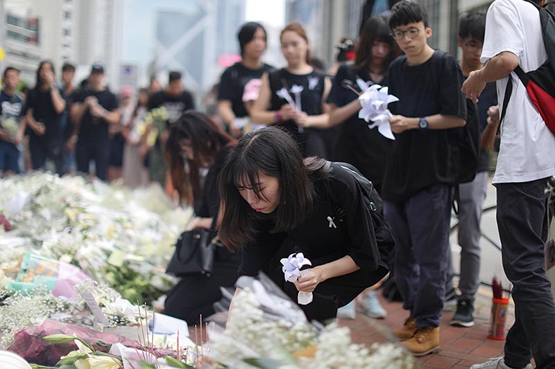 People pay their respects at the site where a man fell from a scaffolding at the Pacific Place complex while protesting against a proposed extradition bill, in Hong Kong, China June 16, 2019. Photo: Reuters