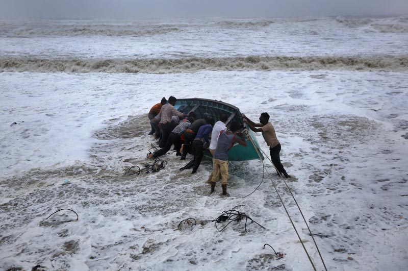 People try to move a fishing boat to a safer ground on the Arabian Sea coast in Veraval, Gujarat, India, Thursday, June 13, 2019. Photo: AP