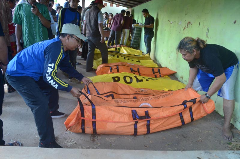 Men arrange body bags containing victims from the boat that sank in the sea between Sapudi and Gili islands, at Dungkek district in Sumenep, East Java province, Indonesia, June 18, 2019. Photo: Antara Foto/Saiful Bahri/ via Reuters