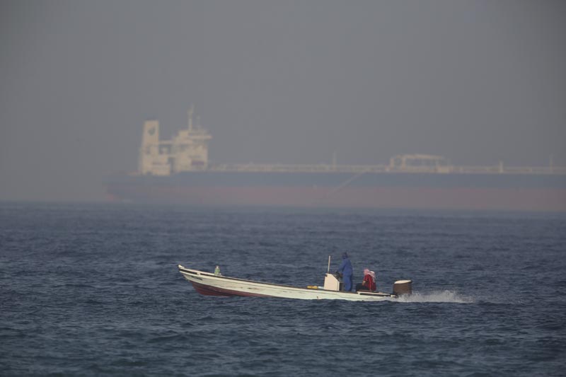 A fishing boat speeds past an oil tanker in the distance in Fujairah, United Arab Emirates, Saturday, June 15, 2019. Photo: AP