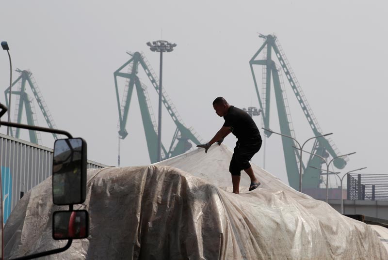 A labourer works outside a logistics center near Tianjin Port, in northern China, May 16, 2019. Photo: Reuters