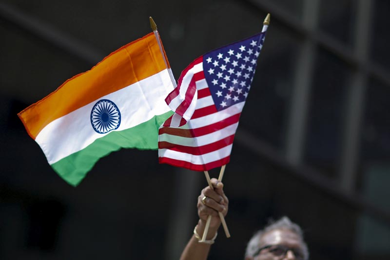 FILE: A man holds the flags of India and the US while people take part in the 35th India Day Parade in New York August 16, 2015. Photo: Reuters/file
