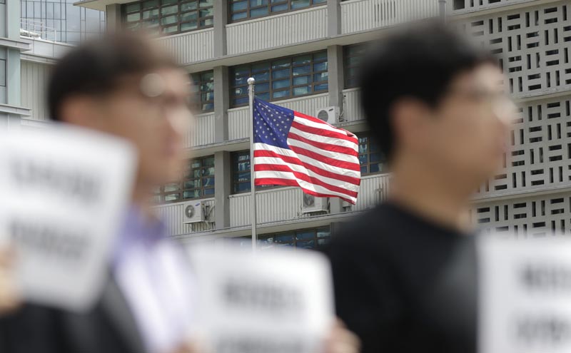 US flag is seen as protesters hold a rally demanding the peace on the Korean peninsula and to stop sanctions on North Korea, ahead of US President Donald Trump's scheduled visit near the US embassy in Seoul, South Korea, Thursday, June 27, 2019. Photo: AP