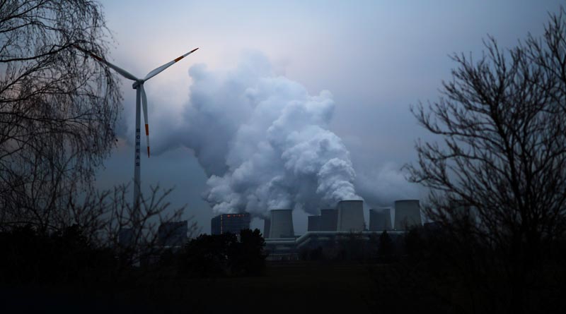FILE PHOTO: Water vapour rises from the cooling towers of the Jaenschwalde lignite-fired power plant of Lausitz Energie Bergbau AG (LEAG) beside a wind turbine in Jaenschwalde, Germany, January 24, 2019. Photo: AP