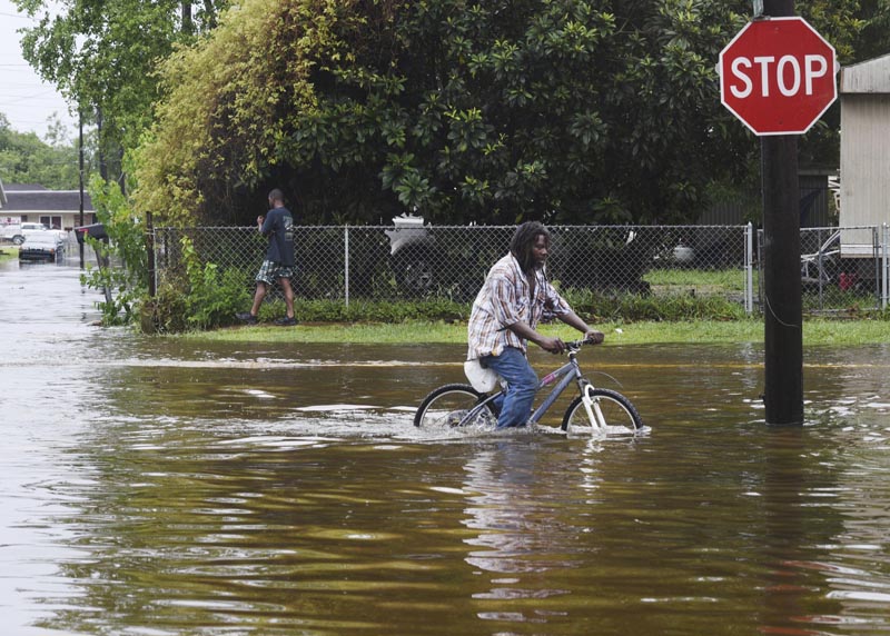 A man tries to bike through the flooding from the rains of storm Barry on LA Hwy 675 in New Iberia, Louisiana, Sunday, July 14, 2019. Photo: Henrietta Wildsmith/The Shreveport Times via AP