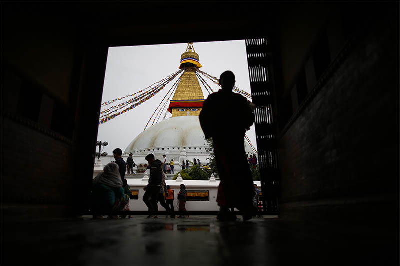 A monk walks inside a monastery in front of the Boudhanath Stupa, a UNESCO world heritage site in Kathmandu, on Wednesday, July 24, 2019. Photo: Reuters
