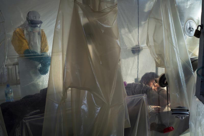 In this Saturday, July 13, 2019 photo, health workers wearing protective gear check on a patient isolated in a plastic cube at an Ebola treatment center in Beni, Congo. Photo: AP
