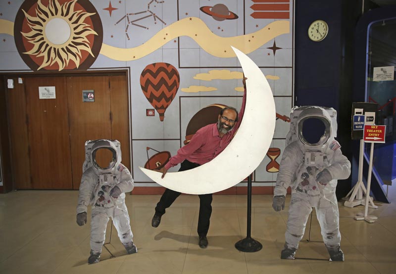 An employee playfully hugs a cut-out of a crescent moon at the Nehru Planetarium in New Delhi, India, Thursday, July 11, 2019. Photo: AP