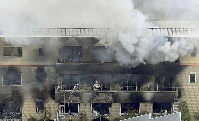 Firefighters work as smoke billows from a three-story building of Kyoto Animation in a fire in Kyoto, western Japan, on Thursday, July 18, 2019. Kyoto prefectural police said the fire broke out Thursday morning after a man burst into it and spread unidentified liquid and put fire. Photo: Kyodo News via AP