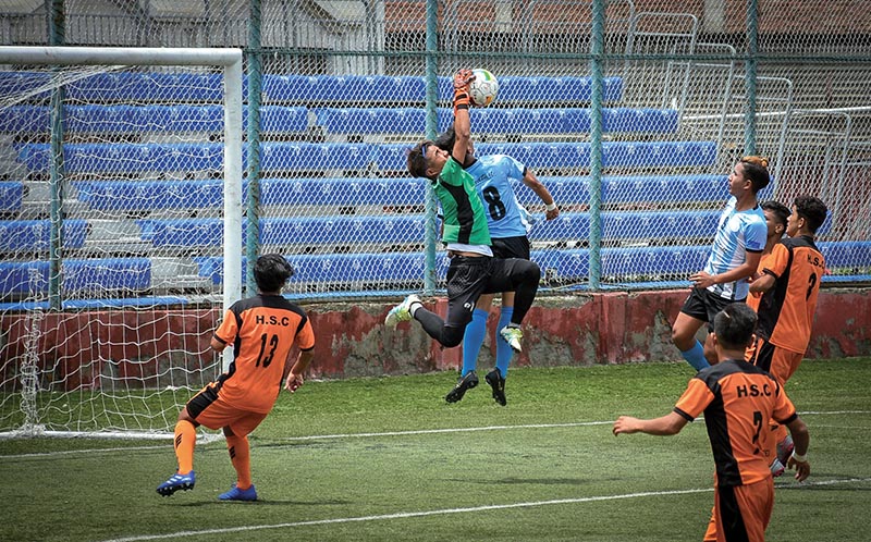 Players of MMC (blue) and HSC vie for ball during their Lalit Memorial U-18 Football Championship match in Lalitpur on Sunday. Photo: Naresh Shrestha / THTu00a0