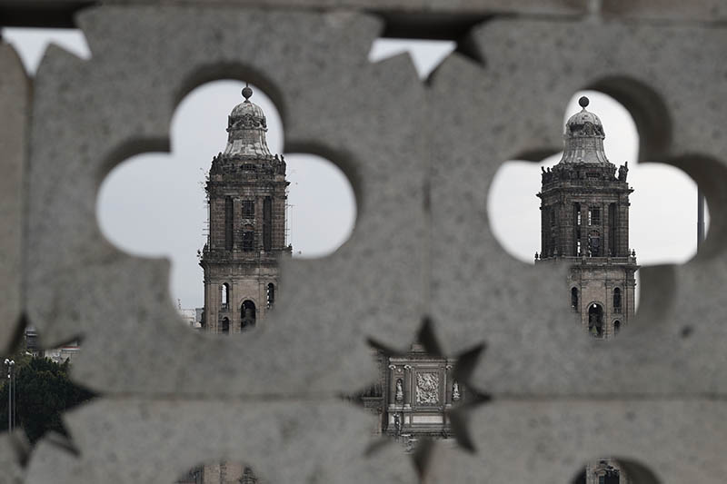 The towers of the Metropolitan Cathedral are seen through masonry atop Old City Hall, ahead of the start of a rally on the one-year anniversary of Mexican President Andres Manuel Lopez Obrador's election, in the Zocalo, Mexico City's main square, Monday, July 1, 2019. Photo: AP