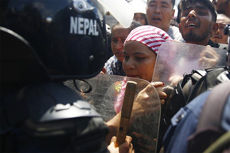 People representing indigenous nationalities grappling with riot police during a protest in front of Federal Public Service Commission office in Anamnagar, Kathmandu, on Thursday, July 18, 2019. Photo: Skanda Gautam/THT
