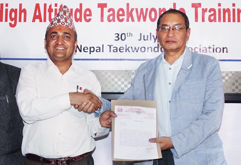 Sailung Rural Municipality Chairman Bharat Prasad Dulal (left) shakes hands with Nepal Taekwondo Association President Prakash Shumsher Rana after handing over the papers during a programme in Lalitpur on Tuesday. Photo: THT