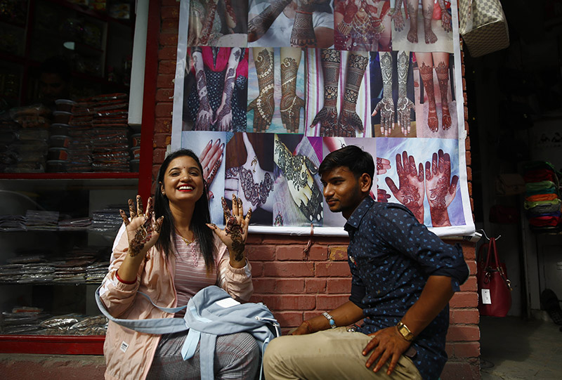 A woman shows her hands decorated with henna on the first day of Shravan -- the month when Hindu women worship Lord Shiva, along a street at New Road, in Kathmandu, on Wednesday, July 17, 2019. Photo: Skanda Gautam/THT