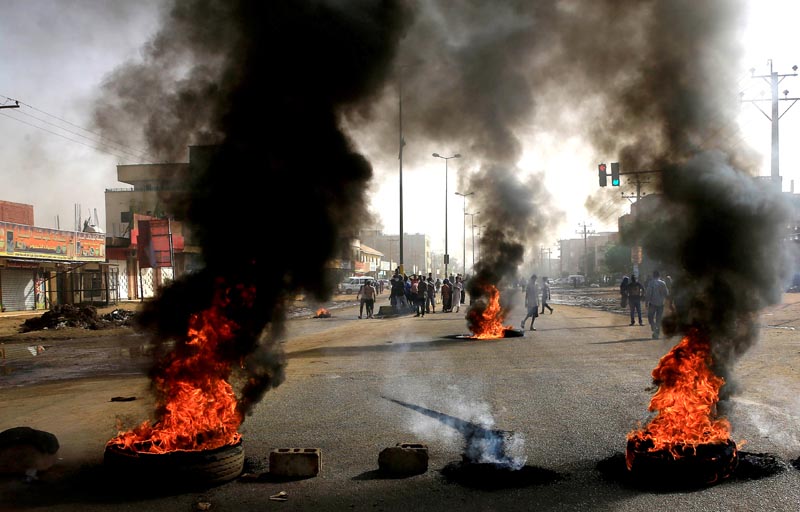 FILE: Sudanese protesters use burning tyres to erect a barricade on a street, demanding that the country's Transitional Military Council hand over power to civilians, in Khartoum, Sudan, June 3, 2019. Photo: Reuters