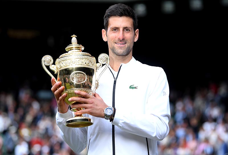 Serbia's Novak Djokovic poses with the trophy as he celebrates winning the Wimbledon final against Switzerland's Roger Federer, at All England Lawn Tennis and Croquet Club, in London, Britain, on July 14, 2019. Photo: Reuters
