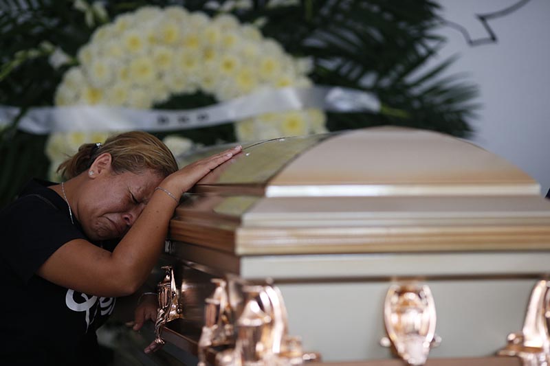 Vanessa Galindo Blas grieves on the coffin that contains the remains of her late husband Erick Hernandez Enriquez, also known as DJ Bengala, who was killed in an attack on the White Horse nightclub where he was DJ'ing, as the family brings his body for burial in the municipal cemetery in Coatzacoalcos, Veracruz state, Mexico on August 29, 2019. Photo: AP