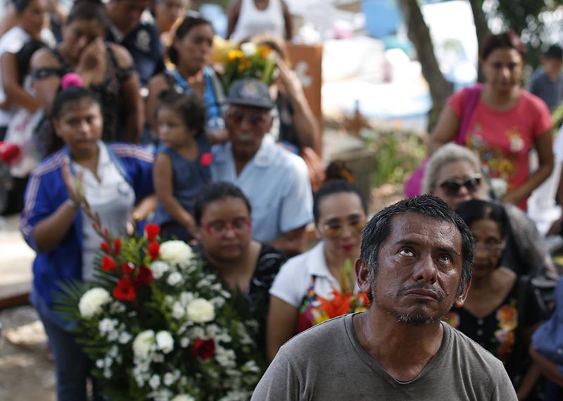 A grieving family member looks to the heavens as mourners bury Maria del Carmen Segovia Padua alongside her aunt Zuleyma Hernandez Sanchez at the municipal cemetery in Coatzacoalcos, Veracruz state, Mexico on August 29, 2019. Photo: AP