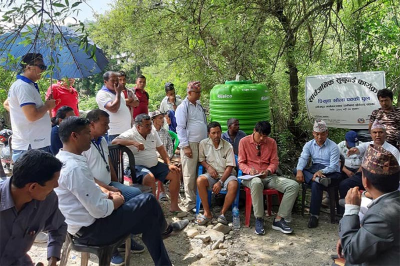 Local residents and stakeholders concerned take part in a public hearing programme organised to inform about the construction of a motorable bridge, in Bhojpur district, on Wednesday, August 21, 2019. The bridge would link Taksar in Bhojpur Municipality-12 with Manebhanjyang in Ramprasad Rai Rural Municipality-5 in the district. Photo: Niroj Koirala/THT