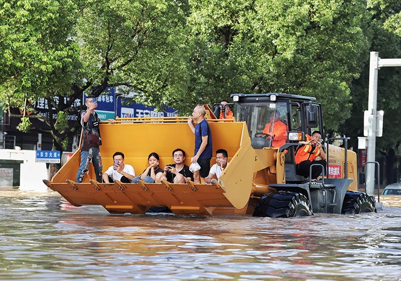 Rescue workers evacuate stranded residents with a bulldozer on a flooded street after typhoon Lekima hit Taizhou, Zhejiang province, China, on August 11, 2019. Photo: Reuters