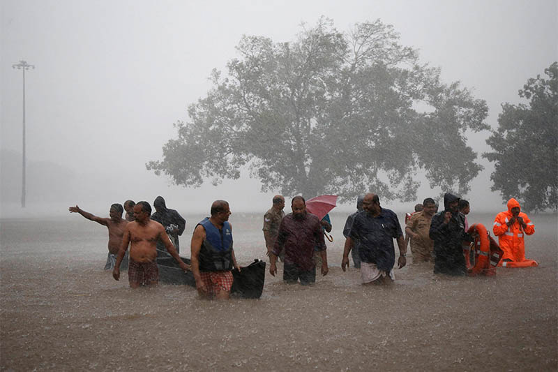 Members of a rescue team wade through a water-logged area during heavy rains on the outskirts of Kochi in the southern state of Kerala, India, August 8, 2019. Photo: Reuters