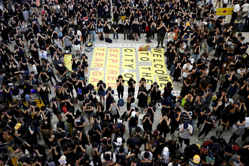 Anti-extradition bill demonstrators cover their eyes during a protest at the arrival hall of Hong Kong Airport, China August 10, 2019. Photo: Reuters