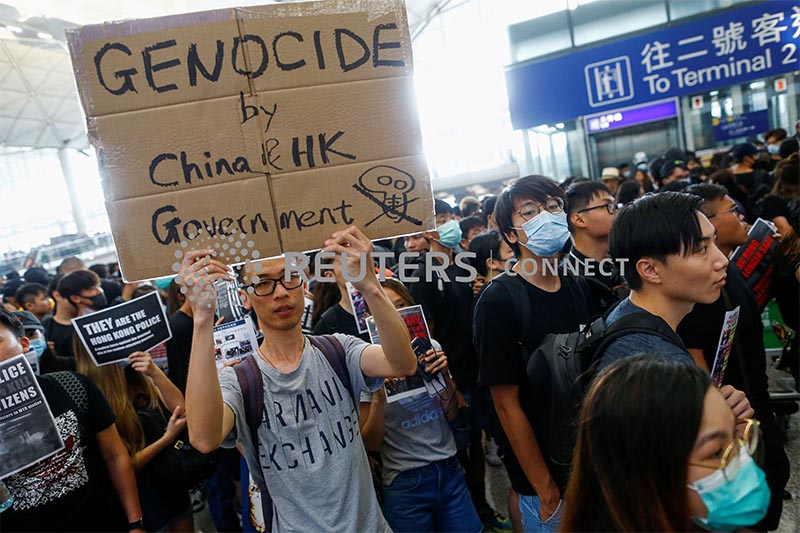 Hong Kong native and Australian resident Jason Tse holds a placard during a protest at the airport in Hong Kong, China August 12, 2019. Photo: Reuters/ File