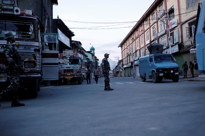 Indian security force personnel stand guard on a deserted road during restrictions after scrapping of the special constitutional status for Kashmir by the Indian government, in Srinagar, August 20, 2019. Photo: Reuters