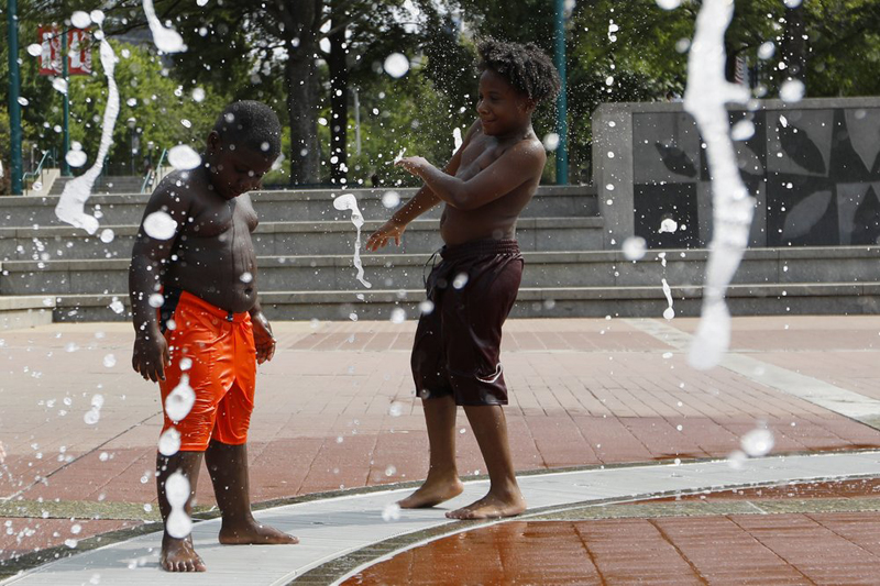 Kai Frazier and Chance Seawright, brothers visiting from Aiken, South Carolina, cool off while playing in the Fountain of Rings in Centennial Olympic Park, Monday, August 12, 2019, in Atlanta. Photo: AP