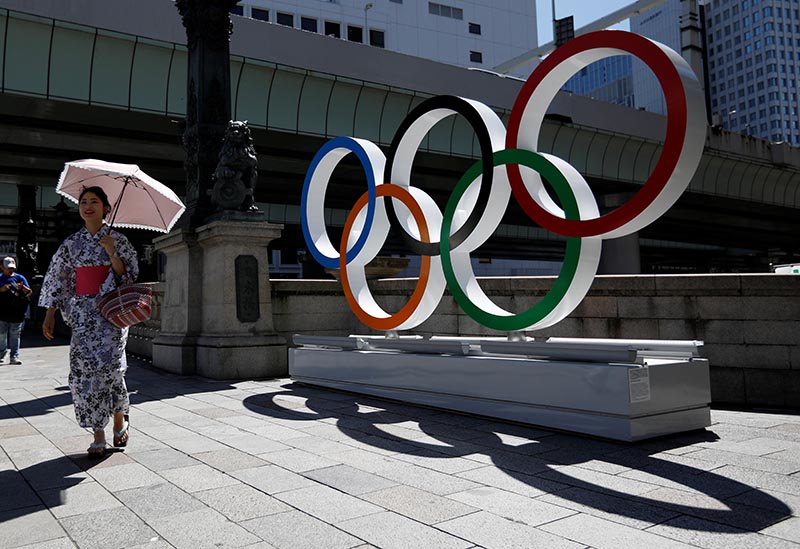 A woman wearing the yukata, or casual summer kimono, walks past Olympic rings displayed at Nihonbashi district in Tokyo, Japan August 5, 2019. Photo: Reuters